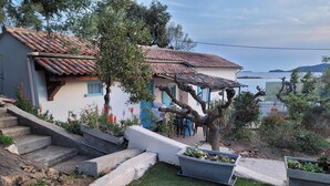 Una casa con techo de tejas, una escalera de piedra y un césped bien cuidado.