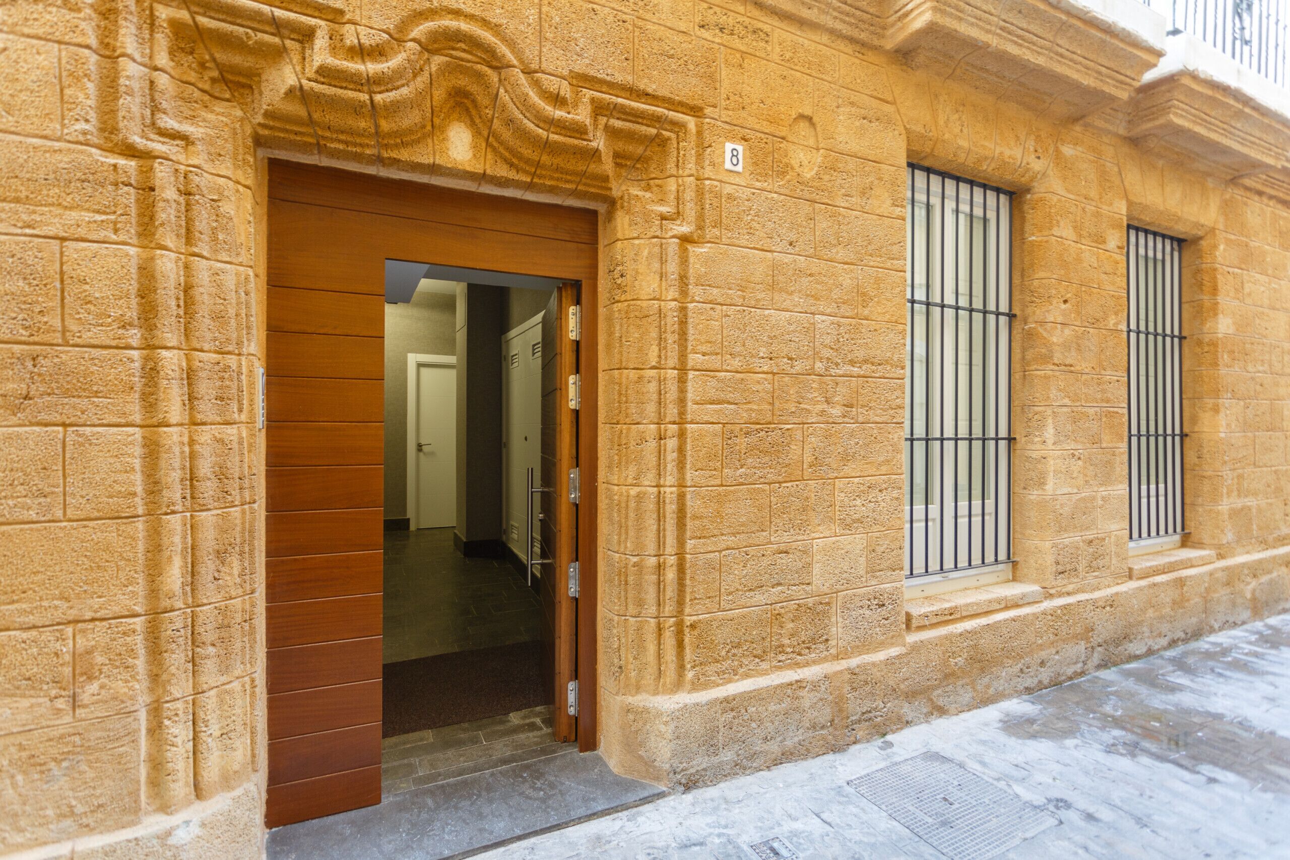 Ein Gebäude aus Stein mit Holztür und vergitterten Fenstern.