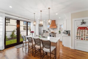Enjoy cooking in this kitchen with a large island, stainless steel range, and copper hood.