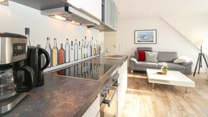 A modern kitchen with a central island, built-in appliances, and a dining area with a sofa and coffee table.