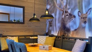 A dining area with a wooden table, two chairs, a bench, and a wall-mounted mirror. - Spacious and clean appart. (4-6 pers.) on piste at Altispace, very centrally located (Valmorel)