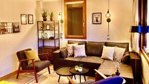 A living room with a sofa, armchairs, a coffee table, and a bookshelf. - Spacious and clean appart. (4-6 pers.) on piste at Altispace, very centrally located (Valmorel)
