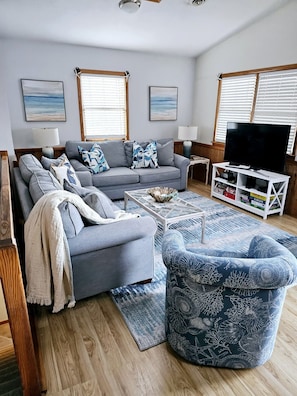 Relax in this stylish living room with a comfortable sofa, armchair, and flat-screen TV.