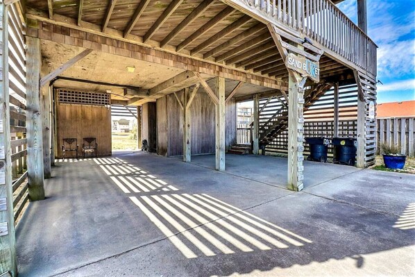 Enter a rustic structure with a covered entrance and open parking area.