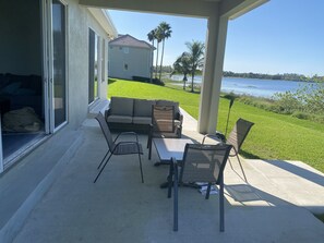 Un patio exterior con un sofá, sillas y una mesa.