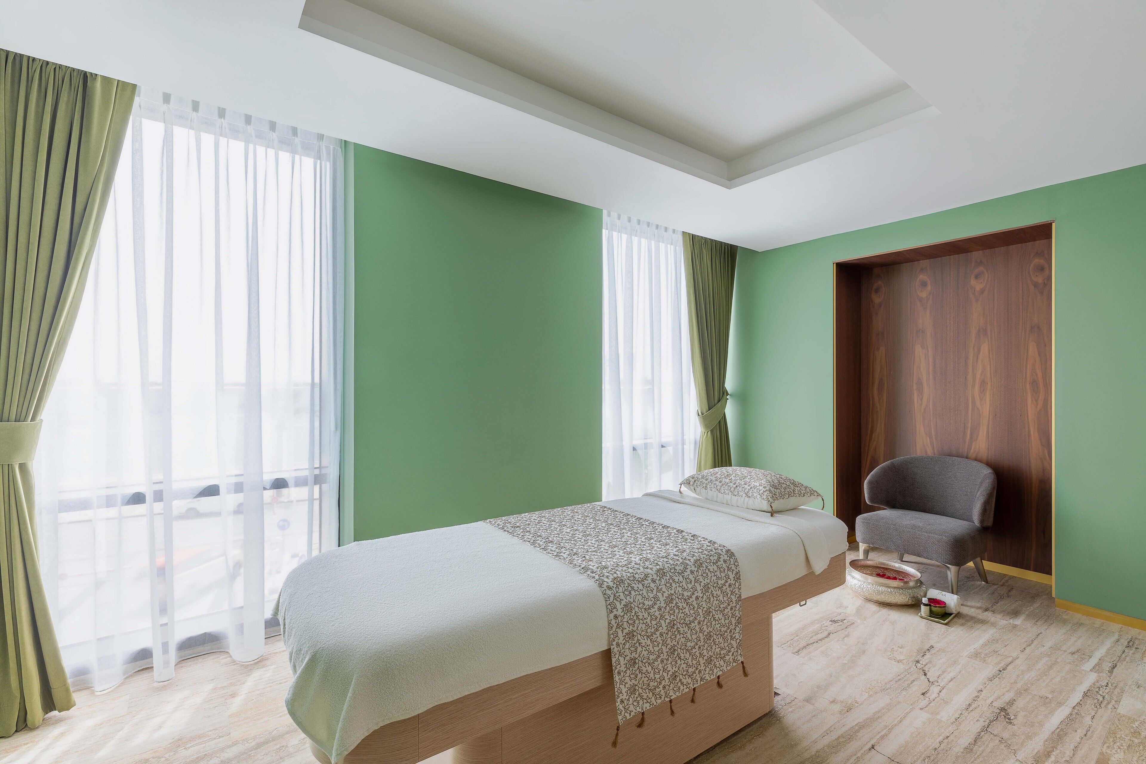 Ein Zimmer mit einem Bett, einem Stuhl und einer Holztür.