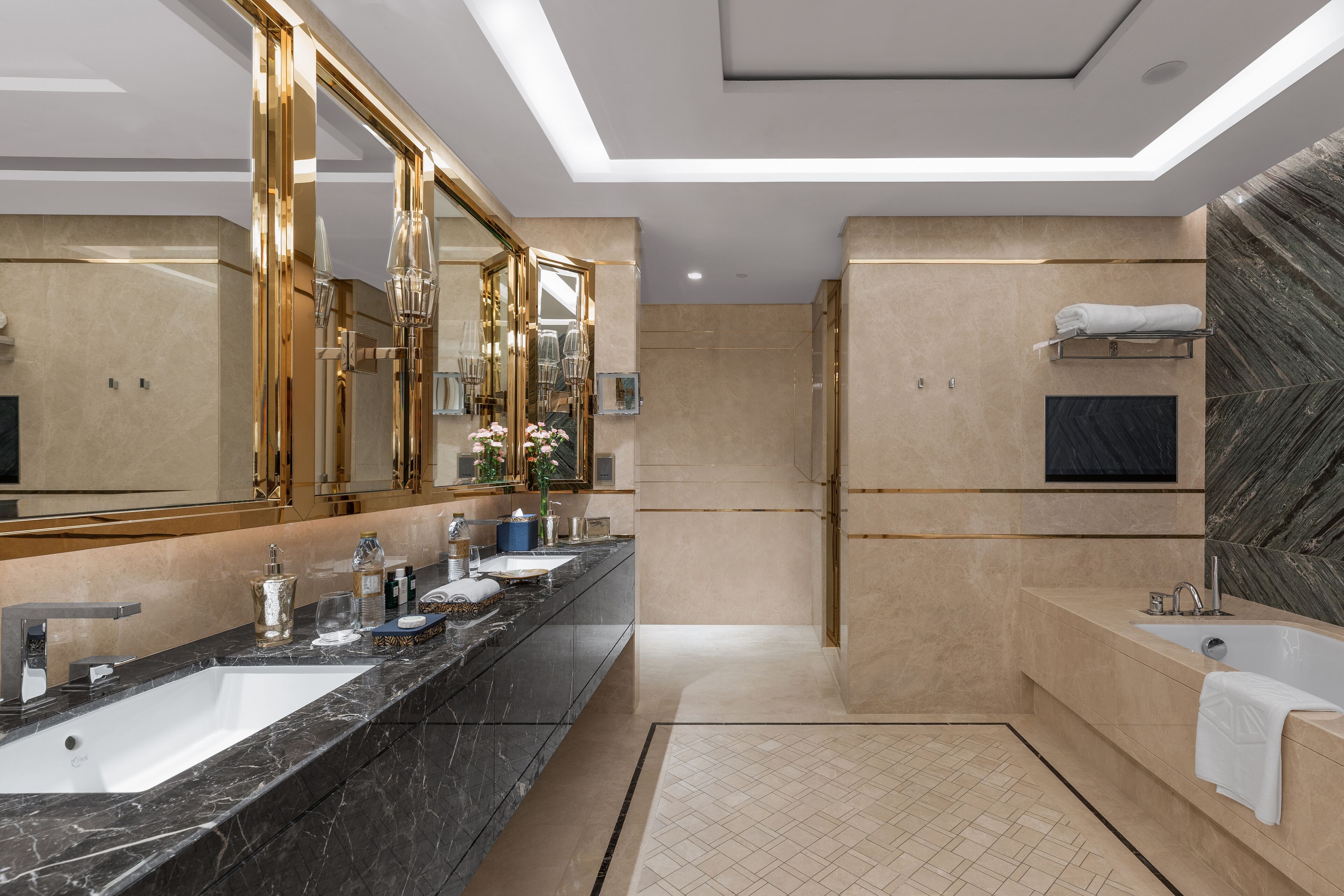 A modern bathroom with a large mirror, two sinks, a bathtub, and a shower.