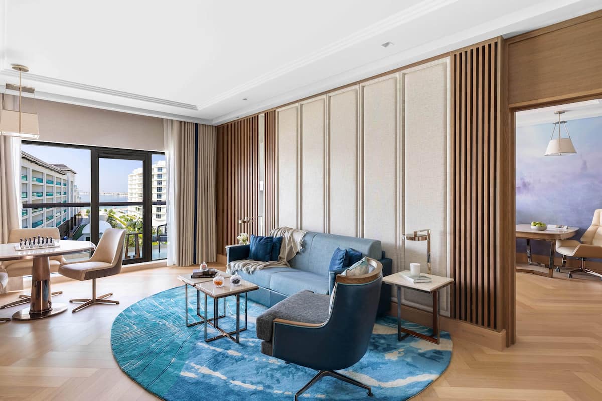 A modern living room with a sofa, coffee table, and a dining area with a table and chairs.