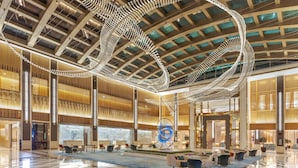 A spacious lobby with a high ceiling, modern lighting fixtures, and a central seating area. - Taj Exotica Resort & Spa, The Palm, Dubai (Dubai)