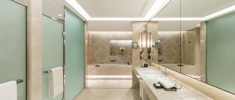 A modern bathroom with two sinks, a large mirror, and a herringbone-patterned wall.