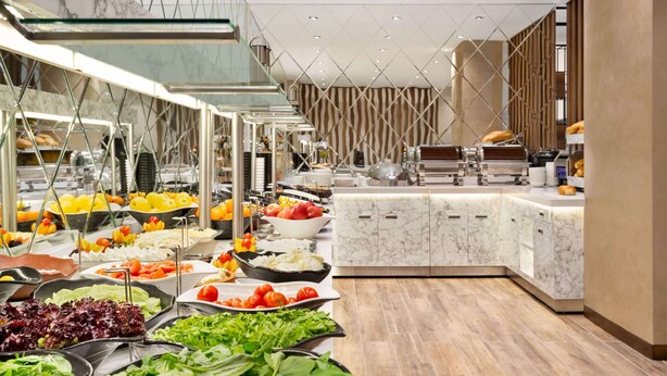 A modern buffet setup with various food items and a marble counter. - Ramada by Wyndham Elbistan (Elbistan)