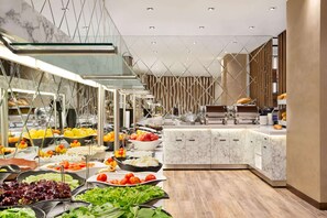 A modern buffet setup with various food items and a marble counter. - Ramada by Wyndham Elbistan (Elbistan)