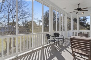 A covered porch with a ceiling fan, white railings, and a table with chairs. - Fabulous Beach Retreat! Walk to the water... (Bay St. Louis)