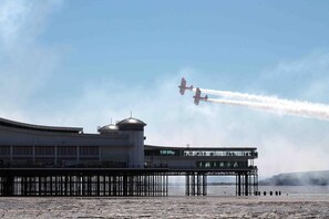 A pier with a building featuring a dome and a viewing platform.