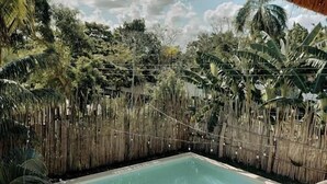 Alberca techada, alberca al aire libre y camastros