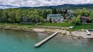 A lakeside property with a dock extending into the water, surrounded by lush greenery and multiple buildings. - Spinnaker Point #1 - Why rent near the beach in Bear Lake when you can rent ON the beach!? (Garden City)