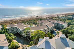 Un hotel sulla spiaggia con diversi edifici, una piscina e vista mare.