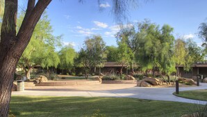 A residential area with a well-maintained lawn, large rocks, and mature trees. - Thunderbird Executive Inn and Conference Center (Glendale)
