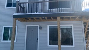 A two-story building with a balcony, a door, and windows. - Adventure Acres- Suite B2 (Holly)