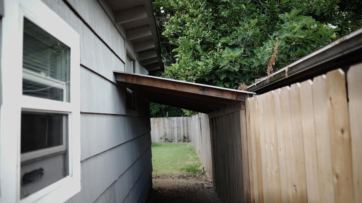A wooden fence and a house with a window.