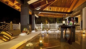 An outdoor seating area with a table, chairs, and a bottle of wine. - Aamod @ Bhimtal (Nainital)