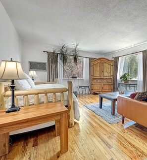 Relax in a cozy room with a comfortable sofa, dining table, and a large window offering a view of the outdoors.