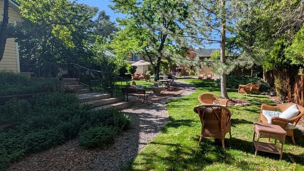 A backyard with a patio area, outdoor furniture, and a garden path. - Rocky Mountain Inn (Paonia)