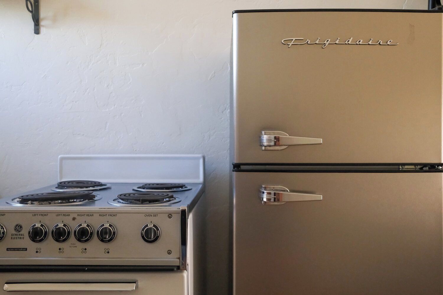 A General Electric stove with four burners and a refrigerator with two doors.