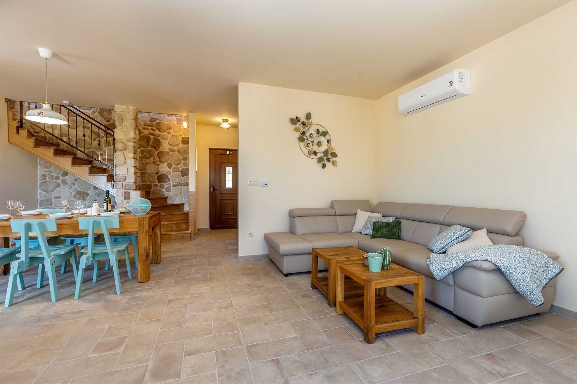 Una sala de estar con sofá, mesa de centro y comedor con sillas y una mesa.
