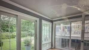 A room with large sliding glass doors leading to a deck, a patterned rug on the floor, and a ceiling with recessed lighting. - In Sag Harbor Village. Walk to town, and less than 1/2 mile to Havens Beach. (Sag Harbor)