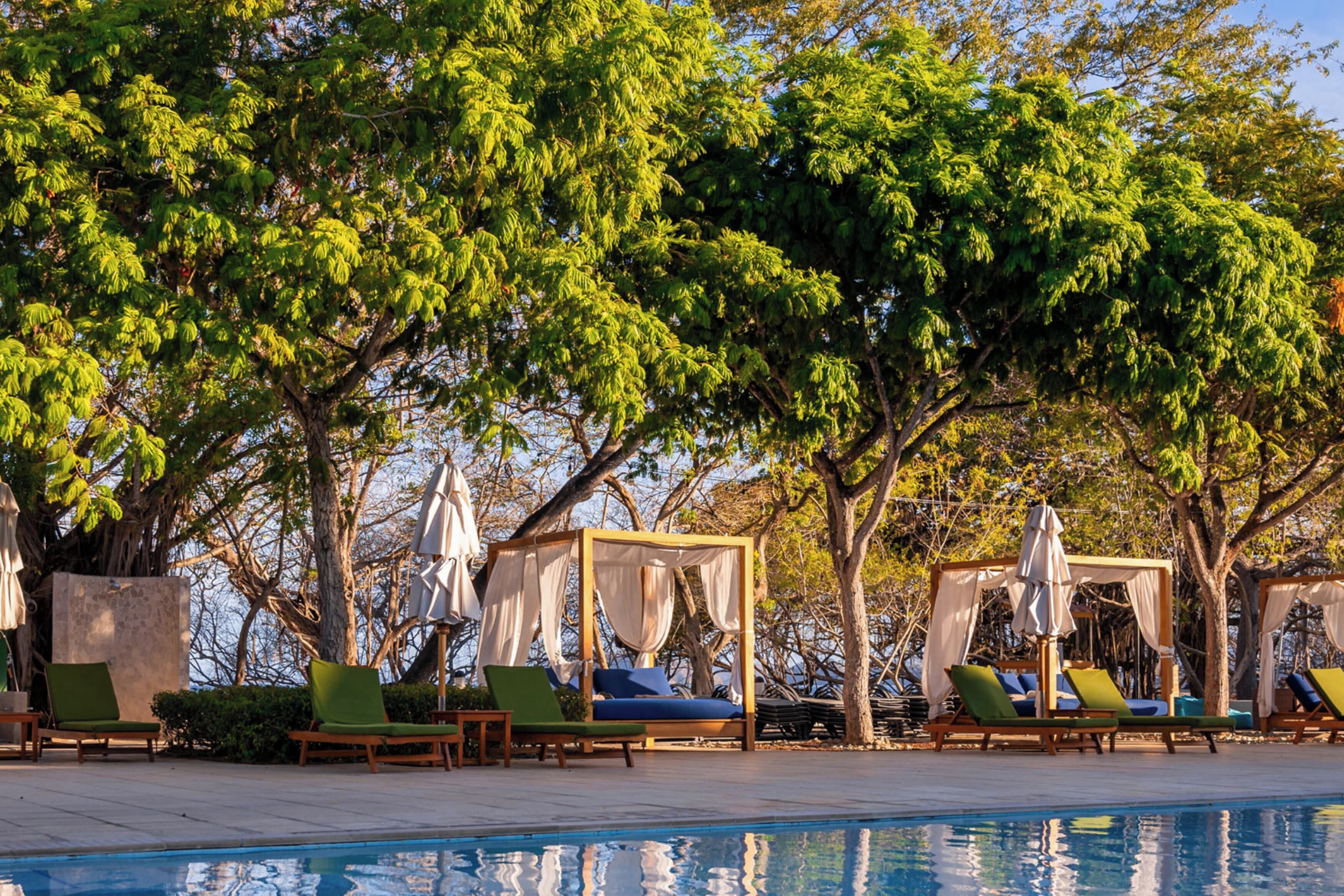 A poolside area with lounge chairs and a canopy structure.