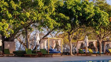 A poolside area with lounge chairs and a canopy structure.