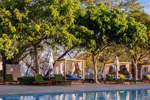 A poolside area with lounge chairs and a canopy structure. - Reserva Conchal Resort - Carao Complex (Cabo Velas)