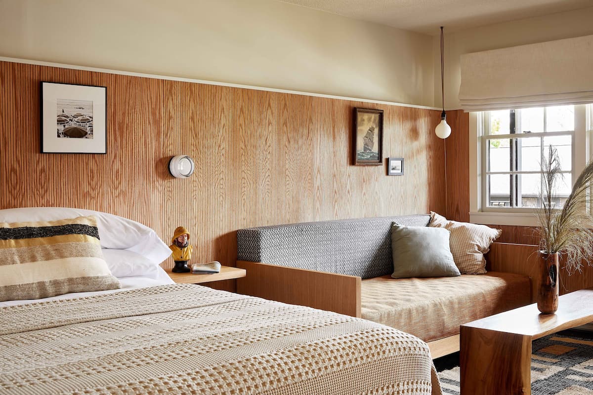 Ein Schlafzimmer mit zwei Betten, einem Schlafsofa, einem Nachttisch und einem Fenster mit Blick.