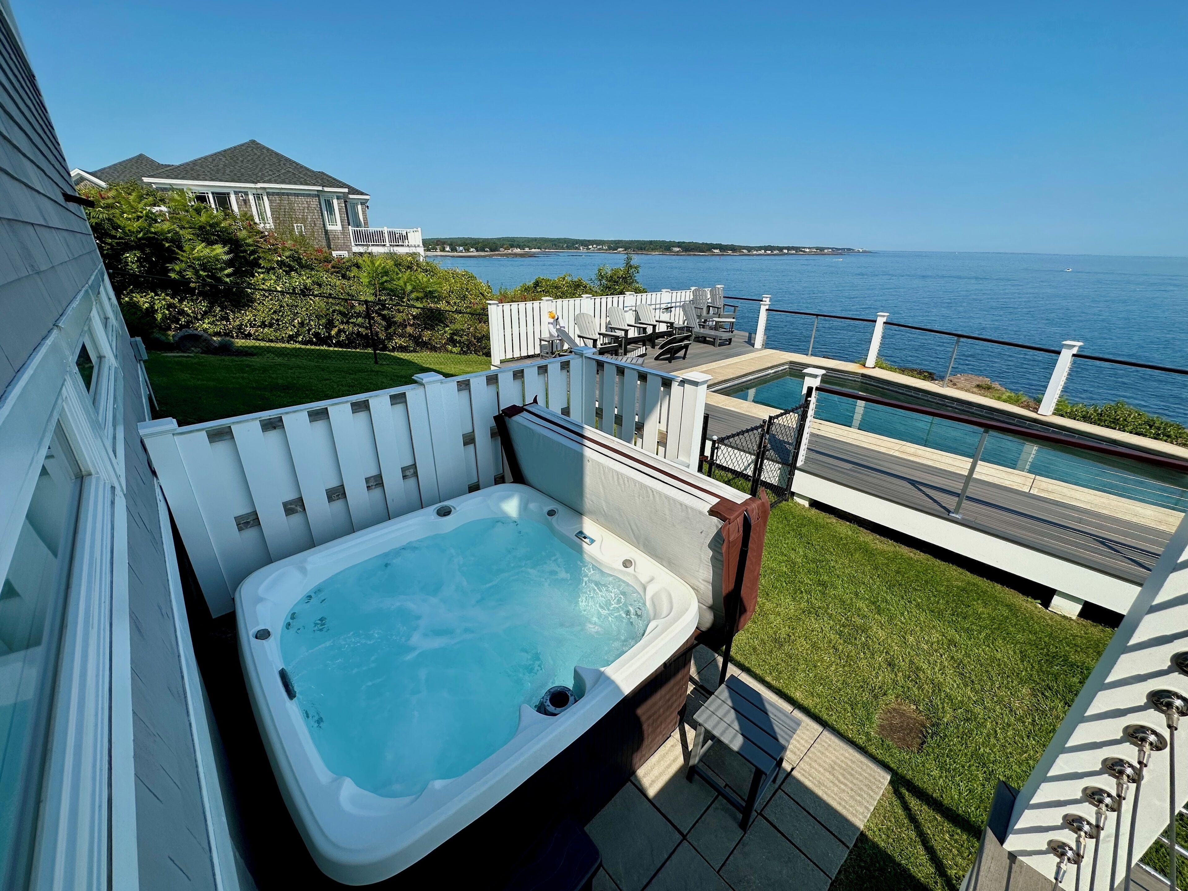 A hot tub on a deck with a view of the sea.