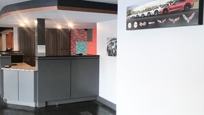 Uma cozinha moderna com uma ilha central, forno embutido e painel decorativo geométrico.
