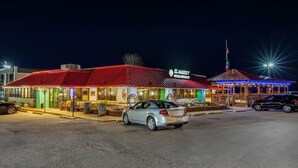 Um edifício com telhado vermelho e uma placa que diz "EL MAGUEY Restaurante Mexicano".