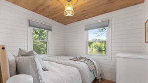 Ein Schlafzimmer mit Bett, Schreibtisch und Fenster.