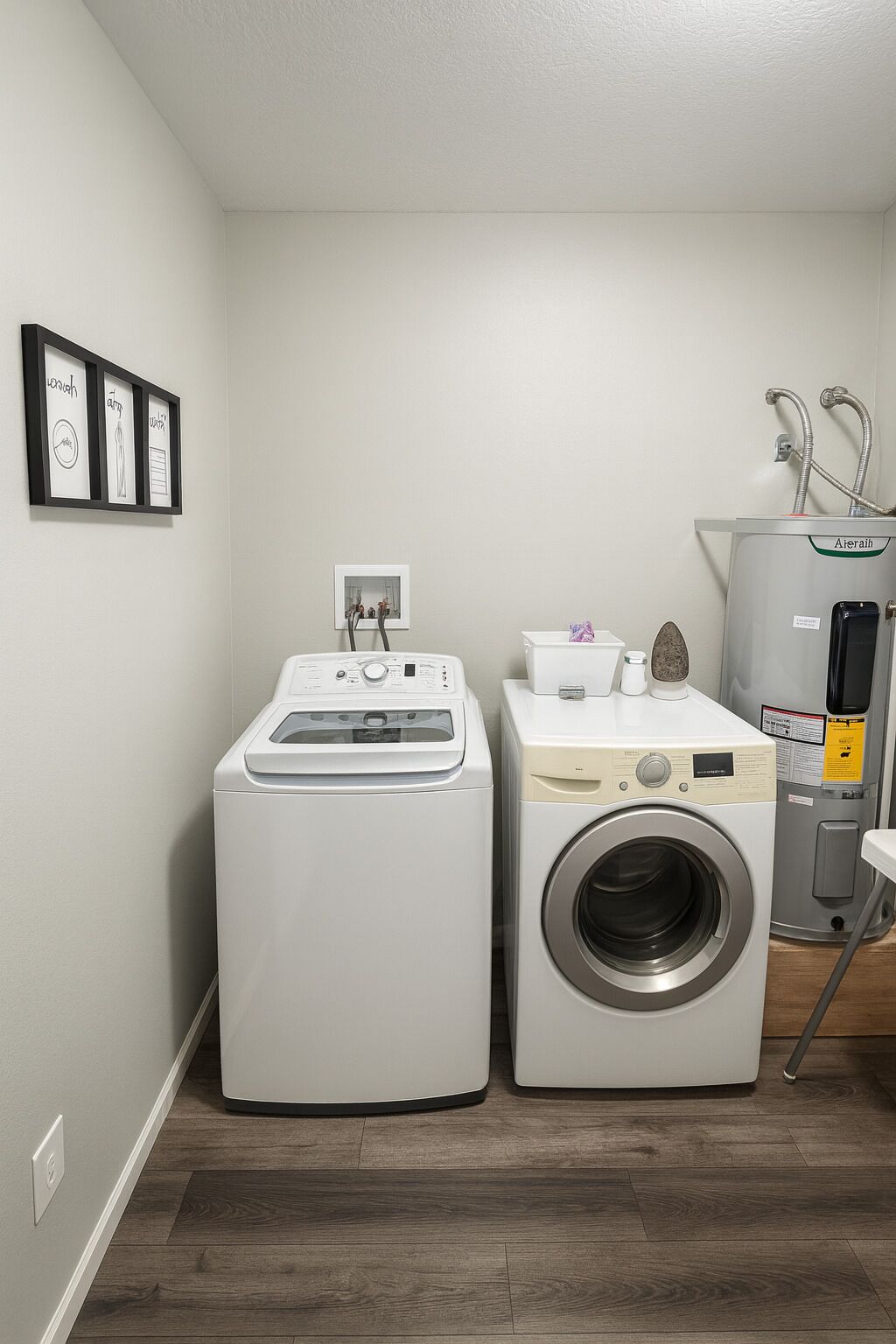 A laundry room with a front-loading washer and dryer, a water heater, and a small sink with a faucet.