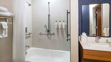 Un baño moderno con ducha, bañera y tocador con espejo.