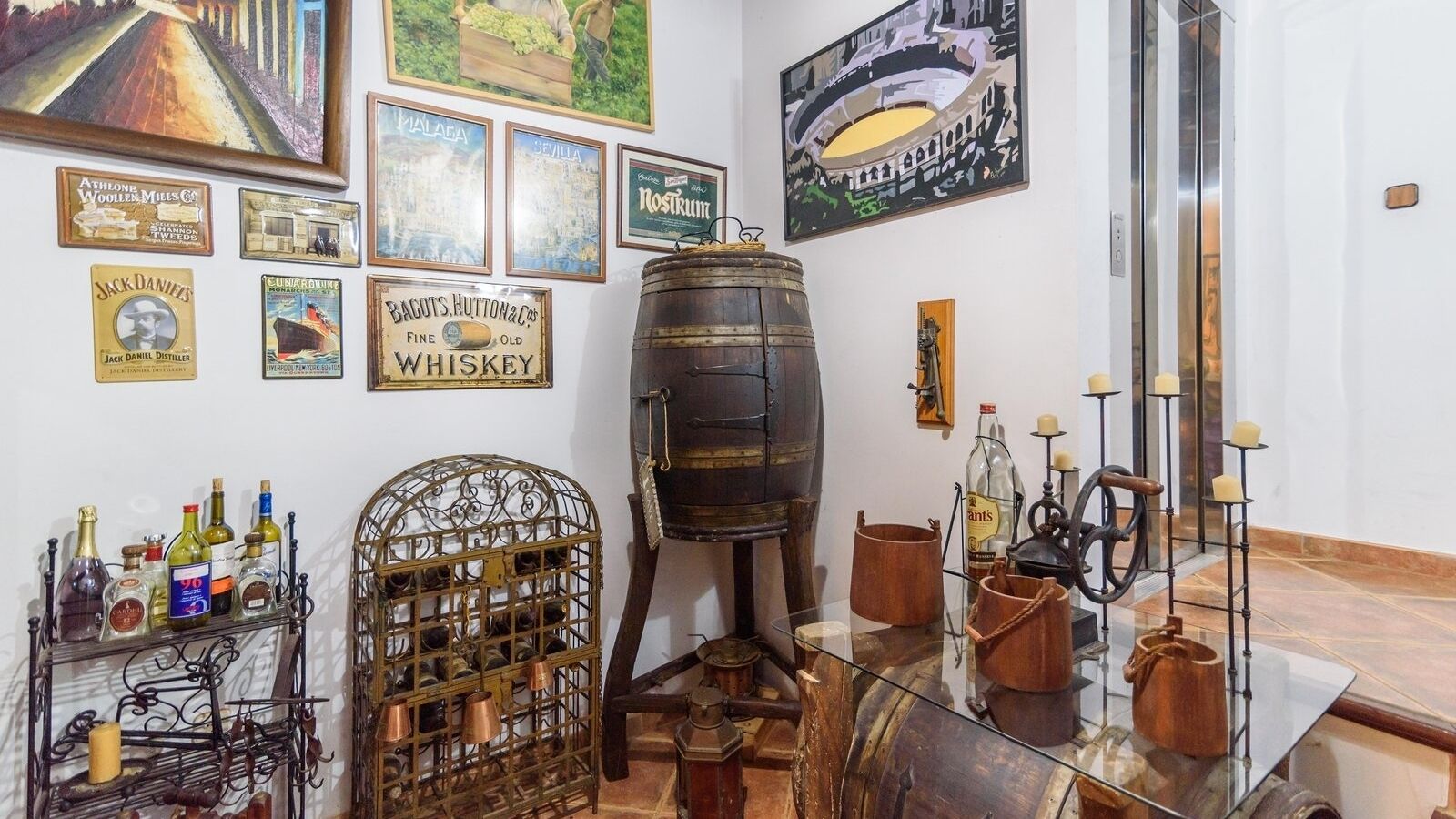 Ett rum i ett whiskydestilleri med en stor träfat, ett metallställ för vinflaskor och olika sorters whiskyflaskor.
