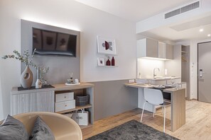 A modern, compact living space with a kitchenette, a dining area, and a seating area. - Myhome Munich (Munich)