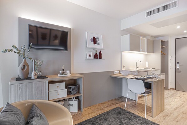 A modern, compact living space with a kitchenette, a dining area, and a seating area. - Myhome Munich (Munich)
