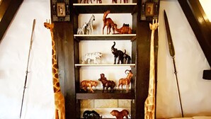 A room with a sloped ceiling, a central shelf with animal figurines, a red bed, and a transparent storage box. - Child-friendly holiday home NAMIBIA-LODGE in the Leppersdorf manor (Wachau OT Leppersdorf)