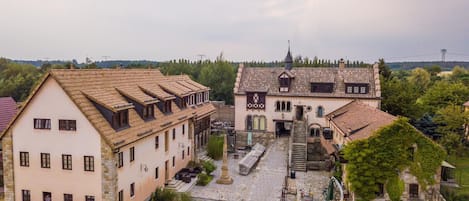 A historic building with a courtyard, stone walls, and a traditional tiled roof.