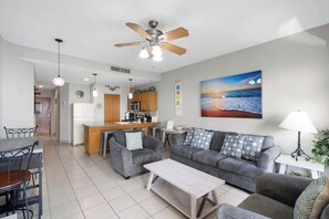 A modern living room with a sofa, coffee table, and dining area.