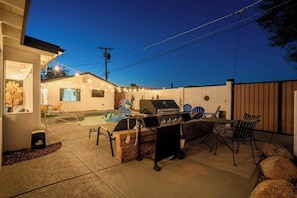 An outdoor patio area with a barbecue grill, seating, and a swimming pool. - BOHO Scottsdale Oasis | Pool (Scottsdale)