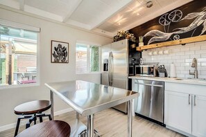 Una cocina moderna con electrodomésticos de acero inoxidable, encimera de madera y vistas al exterior.