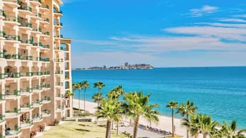 Ein Hotel mit mehreren Balkonen mit Blick auf einen Strand und das Meer.