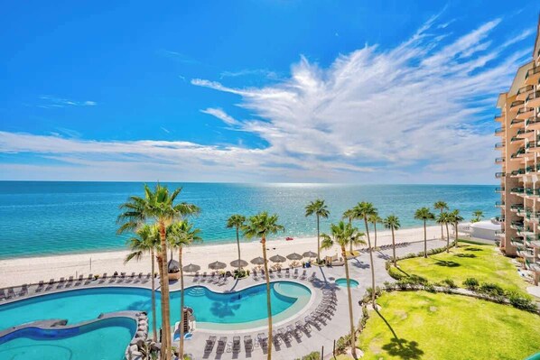 A resort with a pool, beach, and ocean view.